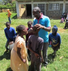 Lawrence groet de lachende kinderen buiten op het gras in JAWA.