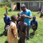Lawrence groet de lachende kinderen buiten op het gras in JAWA.