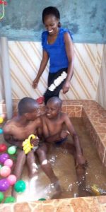 twee jongens zitten in bad, therapeute kijkt toe